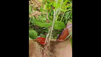 Village Woman In A Red Tunic Is Pissing In The Middle Of A Green Field